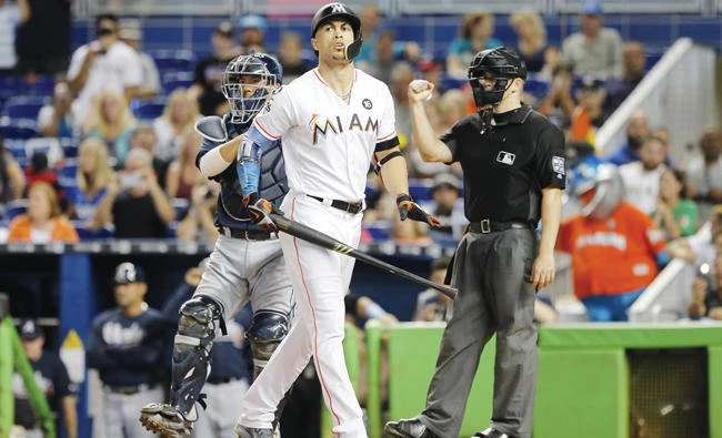 Giancarlo Stanton of the Miami Marlins reacts after striking out in the ninth inning in front of Kurt Suzuki of the Atlanta Braves, ending his bid for 60 home runs for the season at Marlins Park on Sunday in Miami, Florida. (AFP)