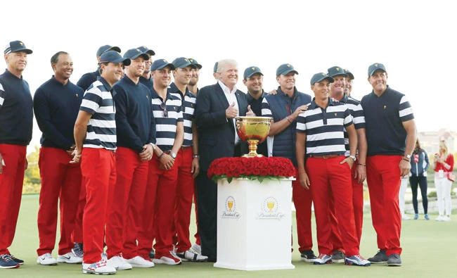 US President Donald Trump poses with the US Team and the trophy after they defeated the International Team 19 to 11 in the Presidents Cup at Liberty National Golf Club on Sunday in Jersey City, New Jersey. (AFP)