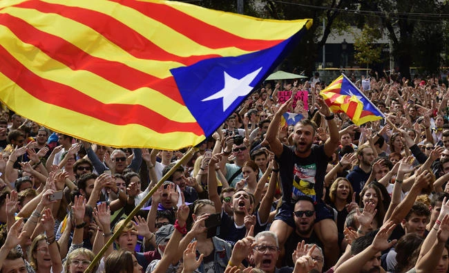 People shout slogans as they wave Catalan pro-independence 'Estelada' flags during a protest in Barcelona on Monday, October 2, 2017, a day after hundreds were injured in a police crackdown during Catalonia's banned independence referendum. (AFP / PIERRE-PHILIPPE MARCOU)