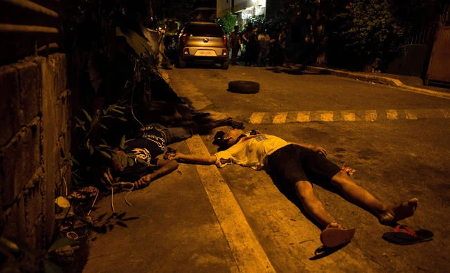 This file photo taken on August 17, 2017, shows the bodies of alleged drug dealers on the road during a police anti-drug operation in Manila. Nearly half of Filipinos believe police are killing innocent people in waging President Rodrigo Duterte's anti-drugs war, according to survey results released Wednesday. (AFP / NOEL CELIS)