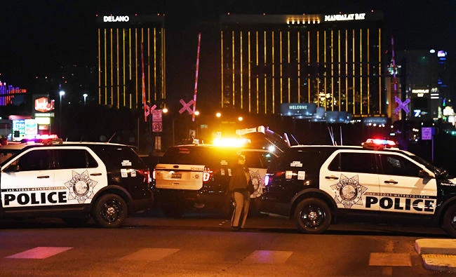 Police form a perimeter around the road leading to the Mandalay Hotel (background) after a gunman killed at least 50 people and wounded more than 200 others when he opened fire on a country music concert in Las Vegas, Nevada on Monday. (AFP)