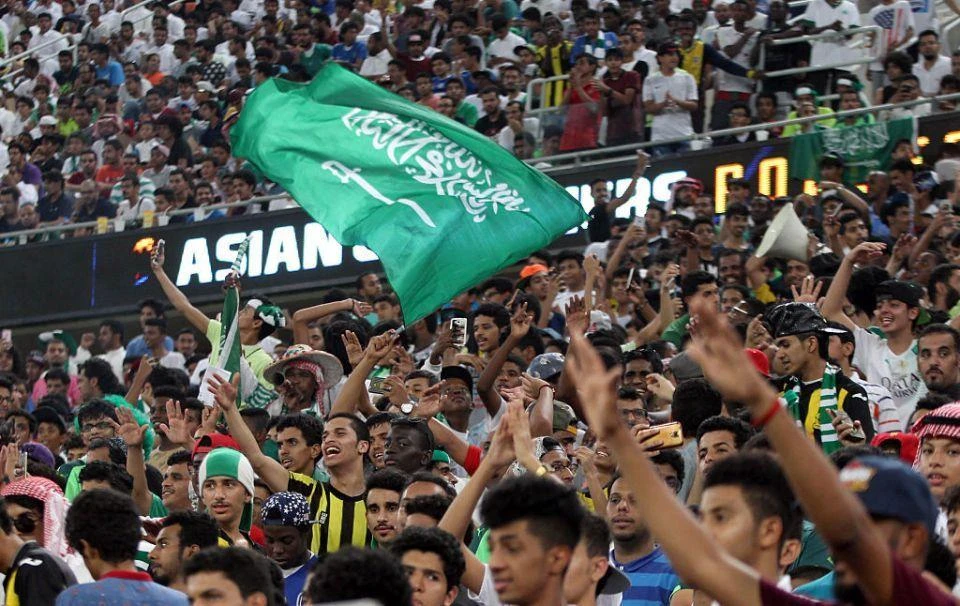 Saudi fans wave the national flag and chant during the 2018 World Cup qualifying football match between Saudi Arabia and United Arab Emirates at the King Abdullah Sports City stadium in Jeddah on October 11 2016 . (AFP)