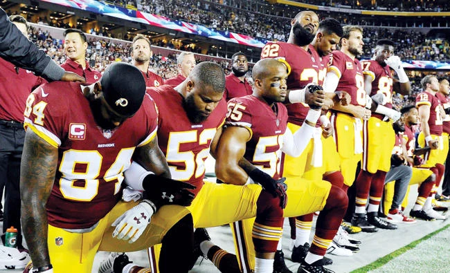 Washington Redskins tight end Niles Paul (84) and linebacker Ryan Anderson (52) and Washington Redskins linebacker Chris Carter (55) kneel with teammates during the playing of the national anthem before the game between the Washington Redskins and the Oakland Raiders at FedEx Field on Sept. 24. (USA TODAY Sports file photo)