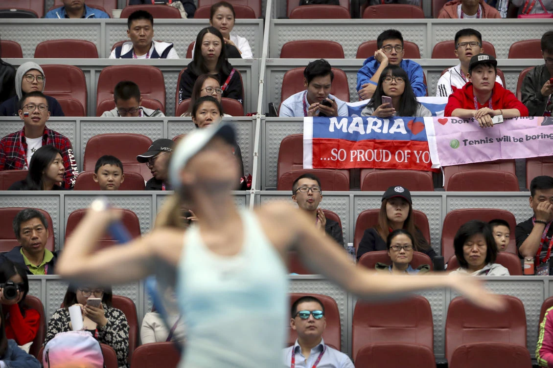 Chinese fans watch Maria Sharapova of Russia warm up before her women’s singles match against Ekaterina Makarova of Russia in the China Open tennis tournament at the Diamond Court in Beijing, Tuesday, Oct. 3, 2017. (AP Photo/Mark Schiefelbein)