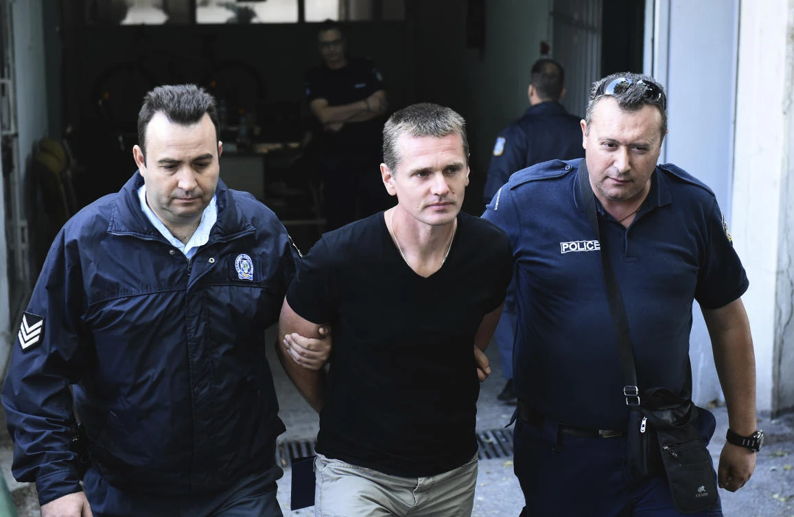 Police officers escort Alexander Vinnik, center as they leave a courthouse in the northern Greek city of Thessaloniki on Wednesday, October 4, 2017. (AP)