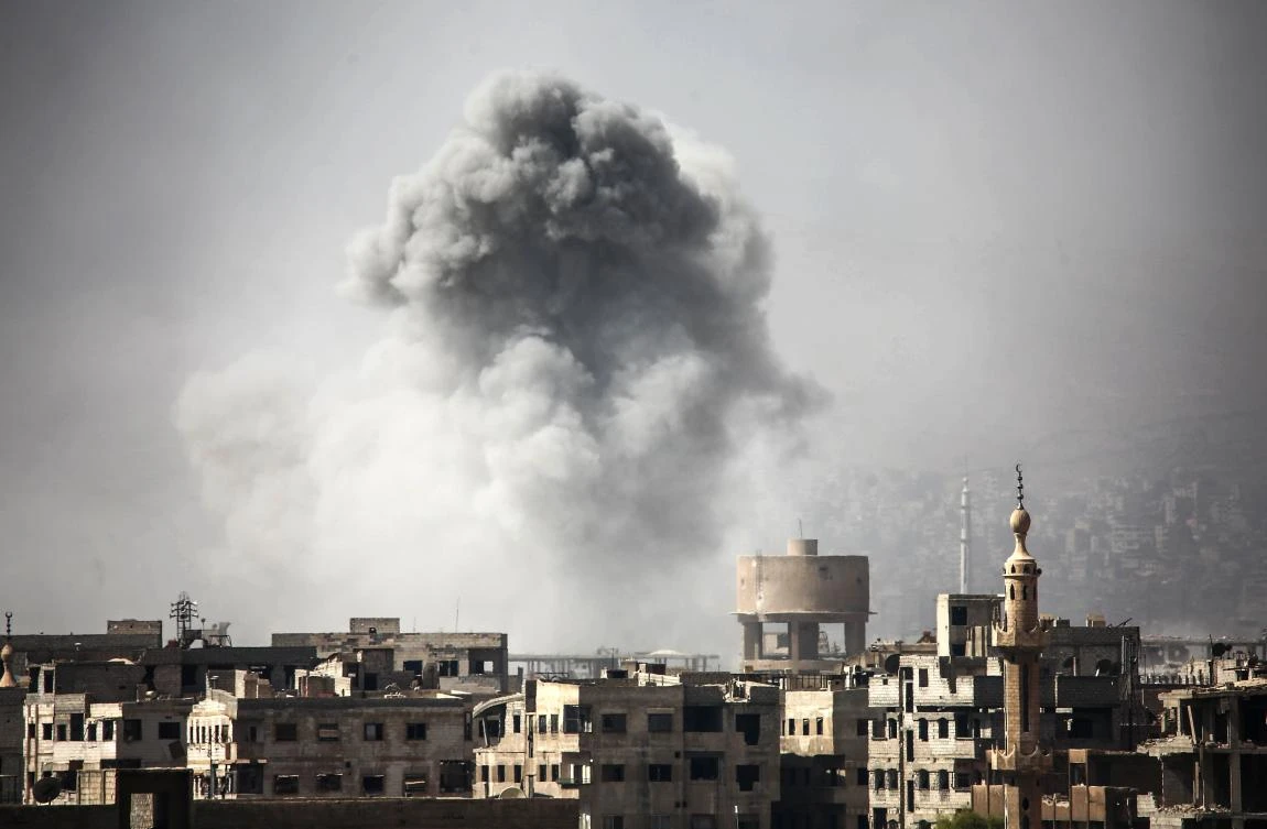 Smoke billows from buildings following a reported air strike on Ain Tarma in the Eastern Ghouta area, a rebel stronghold east of the Syrian capital, on October 2, 2017. (File photo by AFP)