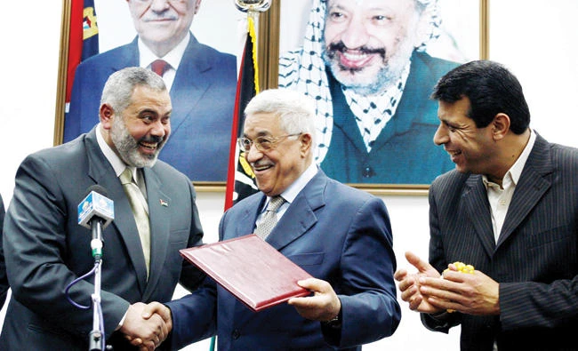 Palestinian President Mahmoud Abbas gives the letter of appointment to then Prime Minister Ismail Haniyeh in Gaza on Feb. 15, 2007. (Reuters)