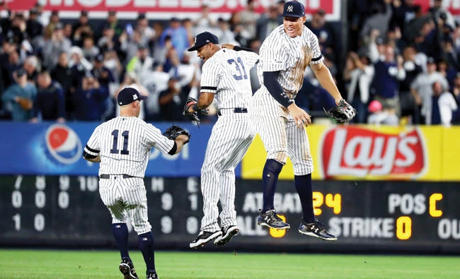 Aaron Judge of the New York Yankees celebrates with Aaron Hicks (31) and Brett Gardner (11) after defeating the Minnesota Twins in
the American League wild card game at Yankee Stadium on Tuesday in the Bronx borough of New York City. (AFP)