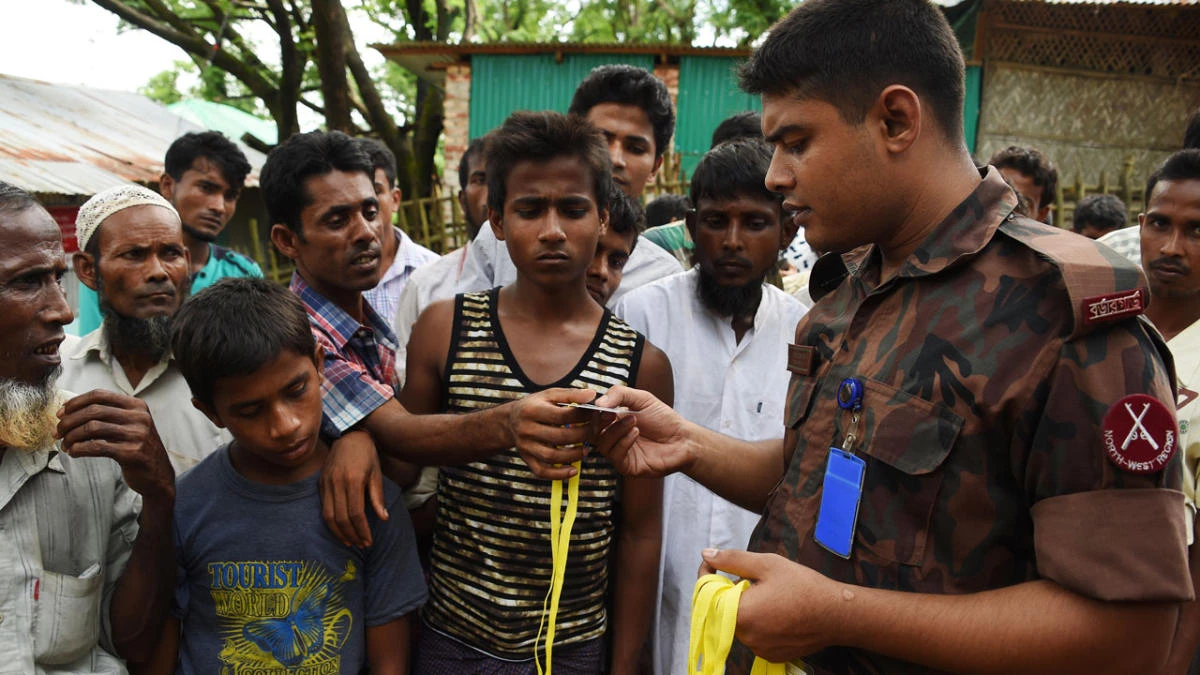 Rohingya refugee receive new ID card from a soldier at the entrance of the Bangladeshi government registration office at the refugee camp of Kutupalong near in Ukhia on September 22, 2017. (AFP)