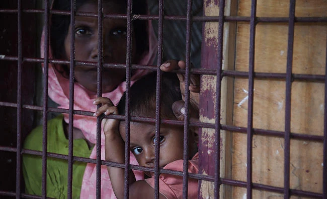 A Rohingya Muslim refugee and child look on as they sit in a school housing new refugees from Myanmar in Kutupalong refugee camp in the Bangaldeshi district of Ukhia on September 23, 2017. (AFP)