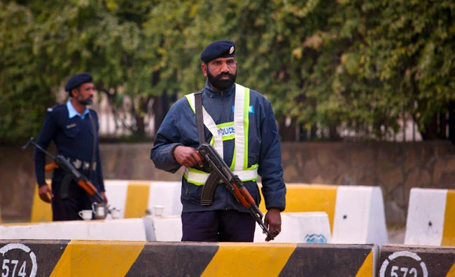 In this file photo, police officers stand guard at an entry point of the parliament building in Islamabad, Pakistan,on Jan. 5, 2014. Pakistan police announced a reward of nearly $5,000 for giving information about a serial attacker, who has stabbed 11 women in the port city of Karachi. (AP)