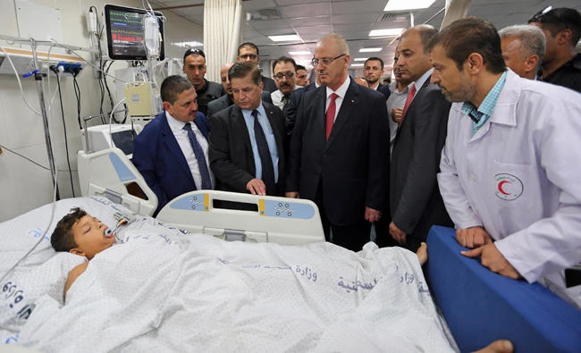 Palestinian Prime Minister Rami Hamdallah, center, and other officials visit a patient in an intensive care room at Shifa Hospital in Gaza City on Thursday. (AP)