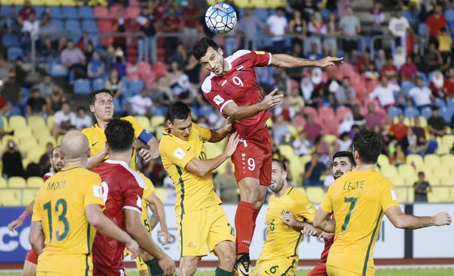 Omar Al-Soma of Syria, center, heads the ball against Australia players during the 2018 World Cup qualifying football match between Syria and Australia at the Hang Jebat Stadium in Malacca on Thursday. (AFP)