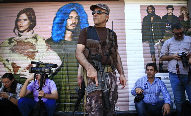 A Turkish police special forces officer secures central Istanbul's Istiklal Avenue, the main shopping road of Istanbul, in this July 2016 file photo. Europe's top human rights and democracy-promoting body says a series of decrees issued by Turkey's government, as part of a state of emergency declared following last year's coup attempt, exceed international democratic standards and Turkey's Constitution. (AP Photo/Lefteris Pitarakis, File)