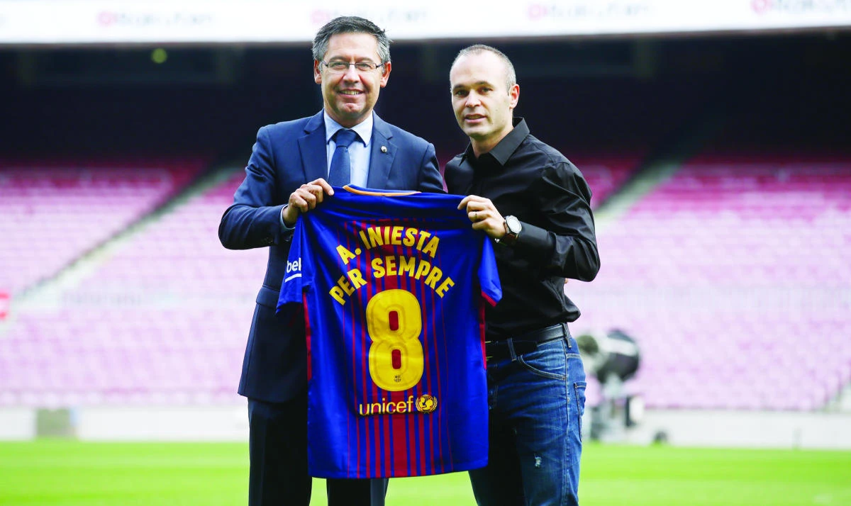FC Barcelona’s Andres Iniesta, right, and FC Barcelona’s President Josep Maria Bartomeu pose with a shirt reading in Catalan: “Andres Iniesta forvever” at the Camp Nou stadium in Barcelona, on Friday. (AP)
