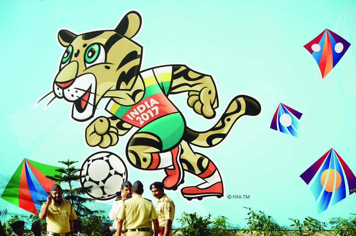 Indian policemen stand near the poster of FIFA U-17 football World Cup mascot at The D.Y. Patil stadium in Navi Mumbai on Thursday. (AFP)