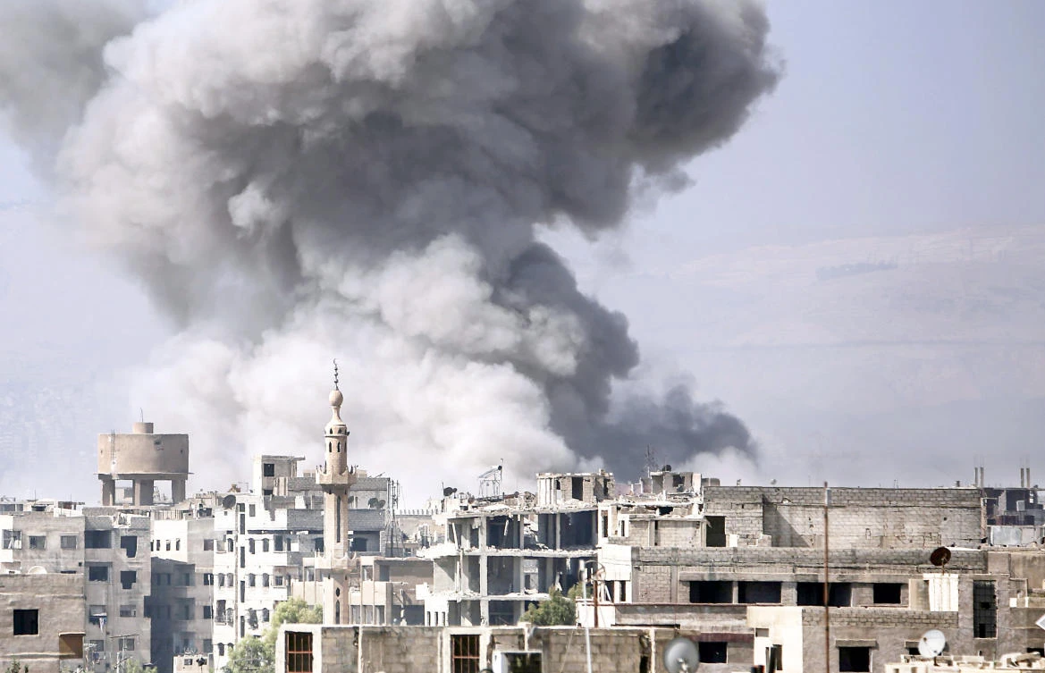 Smoke rises from buildings following an airstrike on an opposition-held area of the Jobar district, east of Damascus on Friday. (AFP)