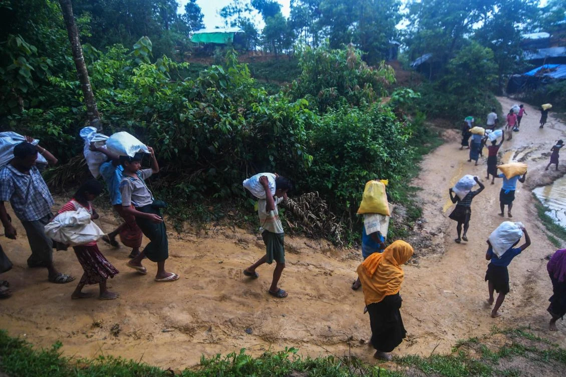 Rohingya refugees walk on a muddy road after collecting relief aid at Kutupalaong refugee camp in Bangladeshi district of Ukhia October 6, 2017. (AFP)
