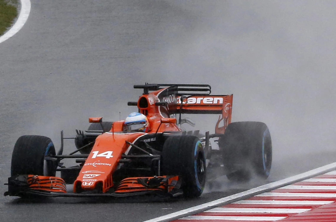 McLaren driver Fernando Alonso of Spain steers his car in the rain during the second practice session for the Japanese Formula One Grand Prix at Suzuka Circuit in Suzuka, central Japan. (AP)