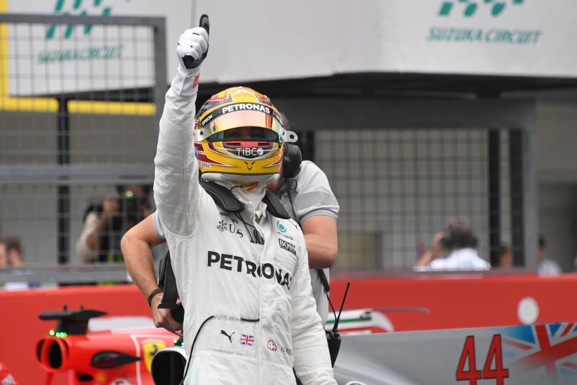 Mercedes' British driver Lewis Hamilton celebrates taking pole position in the qualifying session of the Formula One Japanese Grand Prix at Suzuka. (AFP)