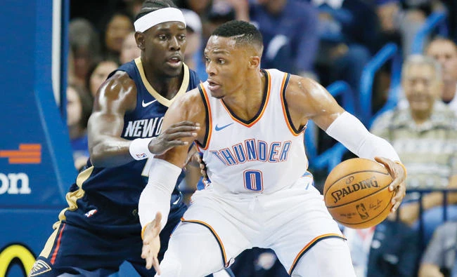 Oklahoma City Thunder guard Russell Westbrook drives against New Orleans Pelicans guard Jrue Holiday, left, during the first quarter of an NBA preseason basketball game in Oklahoma City Friday. (AP)