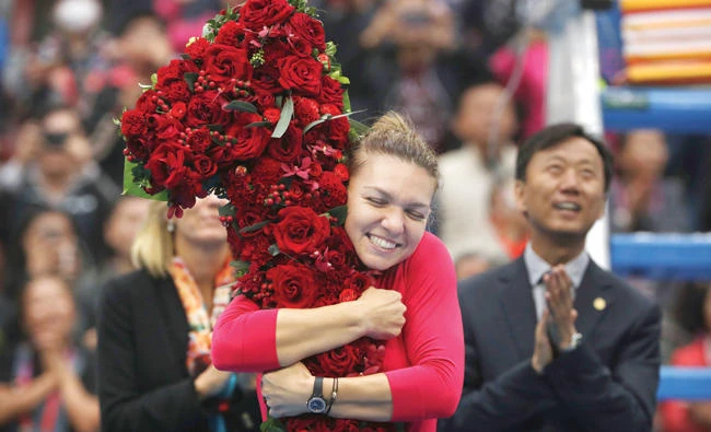 Simona Halep of Romania hugs a floral bouquet in the shape of the No. 1 after beating Jelena Ostapenko of Latvia in their women’s singles semifinal in the China Open tennis tournament at the Diamond Court in Beijing Saturday. (AP)