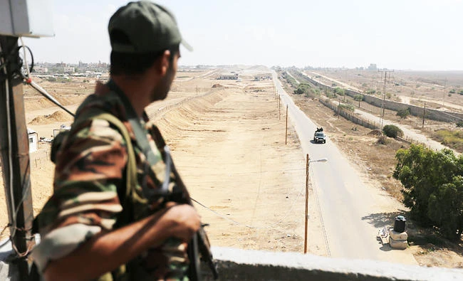A member of Palestinian security forces loyal to Hamas stands guard as his comrades patrol on the border with Egypt, in Rafah, in the southern Gaza Strip on Sunday. (REUTERS)
