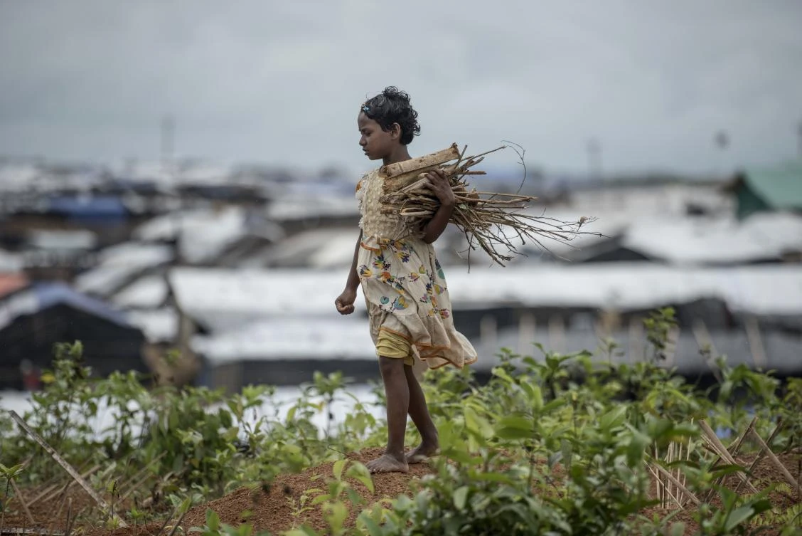 A young Rohingya Muslim refugee collects wood among graves at Kutupalong refugee Camp in Bangladesh's Ukhia district on October 7, 2017. A top UN official said Saturday Bangladesh's plan to build the world's biggest refugee camp for 800,000-plus Rohingya Muslims was dangerous because overcrowding could heighten the risks of deadly diseases spreading quickly. The arrival of more than half a million Rohingya refugees who have fled an army crackdown in Myanmar's troubled Rakhine state since August 25 has put an immense strain on already packed camps in Bangladesh. (AFP)