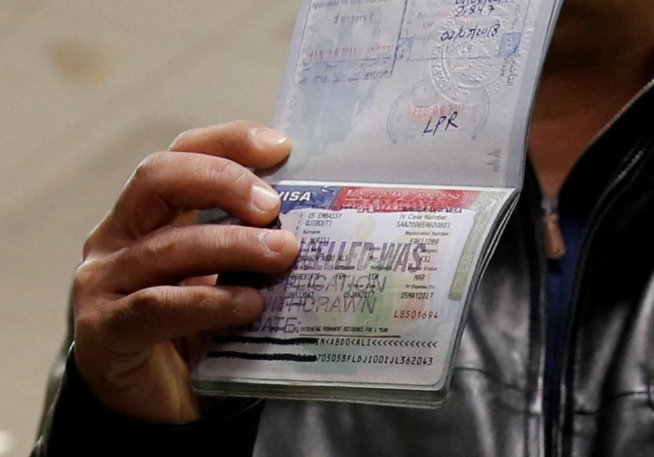Man denied entry into the U.S. because of the recent travel ban, shows the cancelled visa in their passport from their failed entry to reporters as they successfully arrive to be reunited with their family at Washington Dulles International Airport in Chantilly, Virginia, U.S. February 6, 2017. (REUTERS)