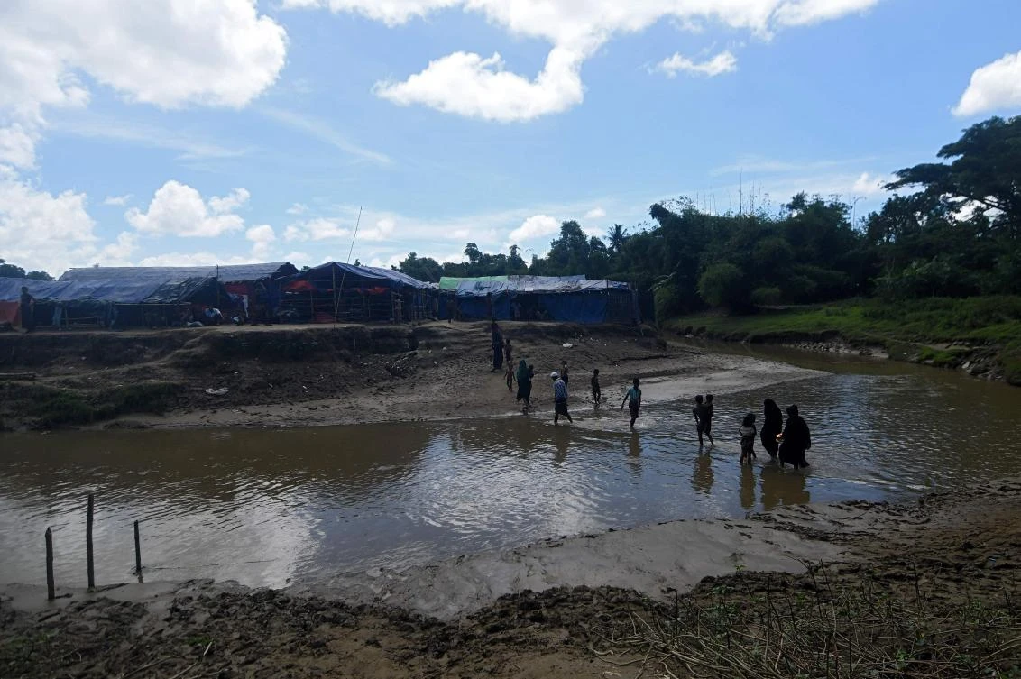 Rohingya refugees cross a canal next to a settlement close to the no man’s land area between the borders of Myanmar and Bangladesh in Tombru Bandarban district on October 10, 2017. (AFP)