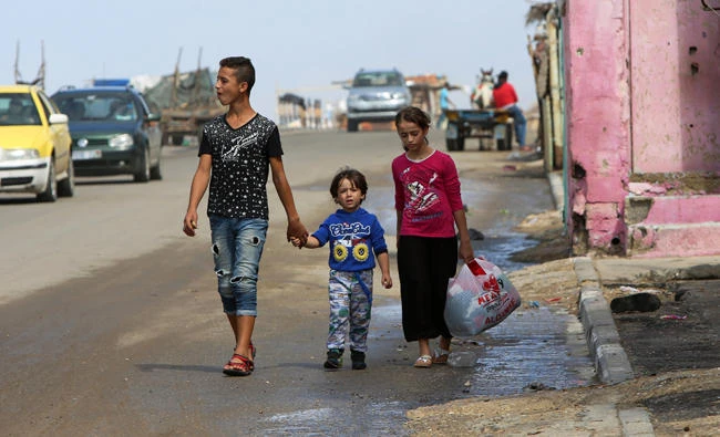 Youngsters walk to the main beach road of the Shati refugee camp in Gaza City on Monday. (AP)