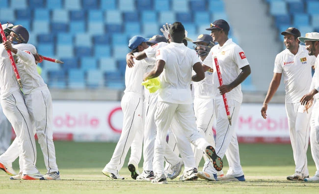 Sri Lanka players celebrate after they beat Pakistan in Second Test cricket match against Pakistan in Dubai Tuesday. (AP)