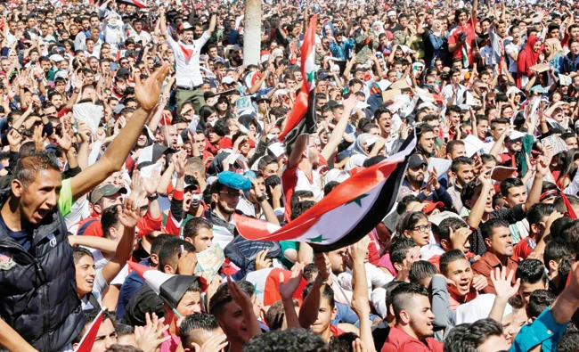 Syrians cheer on their national team at the Umayyad Square in Damascus as they watch a live broadcast of the World Cup 2018 qualifying playoff football match betwen Syria and Australia on Tuesday. (AFP)