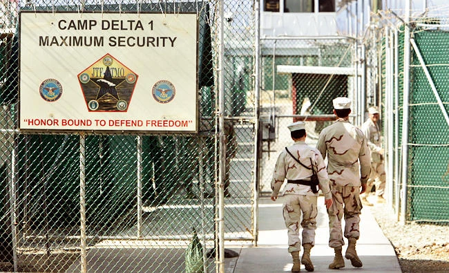 In this June 27, 2006 file photo, reviewed by a U.S. Department of Defense official, U.S. military guards walk within Camp Delta military-run prison, at the Guantanamo Bay U.S. Naval Base, Cuba. (AP)