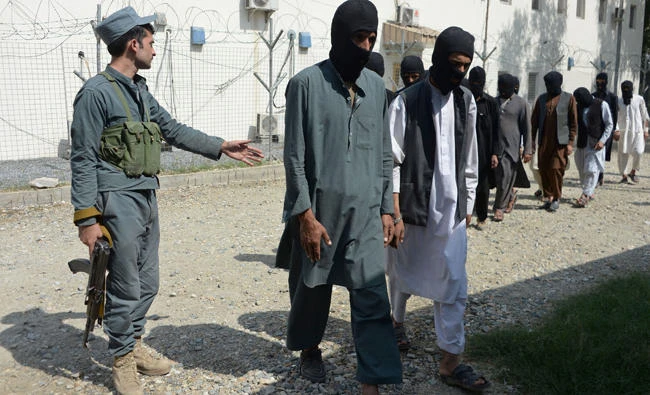 Afghan security forces escort alleged Daesh and Taliban militants being presented to the media at the police headquarters in Jalalabad on October 3, 2017. Representatives of Afghanistan, China, Pakistan and the US will meet in Oman next week to discuss reviving peace talks with Afghan Taliban militants. (AFP / Noorullah Shirzada)