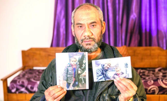 Faouzi Trabelsi shows in Tunis a photo of himself with his grandson, Tamim Jaboudi, who has been trapped in a prison in Libya since his parents, both Tunisians, who left home to join Daesh, died in a US airstrike in February 2016. (AP)