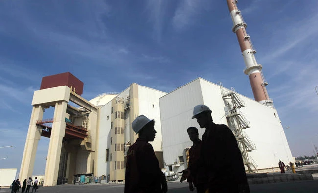 Iranian workers stand in front of the Bushehr nuclear power plant, about 1,200 km south of Tehran, in this file photo of Oct. 26, 2010. (Reuters)