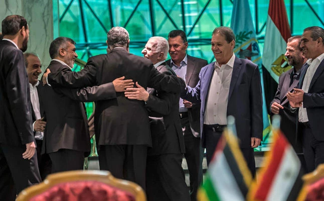 Khaled Fawzi (3rd-L) head of the Egyptian Intelligence services, shares a laugh with Hamas leader Izzat al-Rishq (2nd-L) and Fatah's Azzam al-Ahmad (C) following the signing of a reconciliation deal in Cairo on October 12, 2017, as the two rival Palestinian movements ended their decade-long split following negotiations overseen by Egypt. (AFP / KHALED DESOUKI)