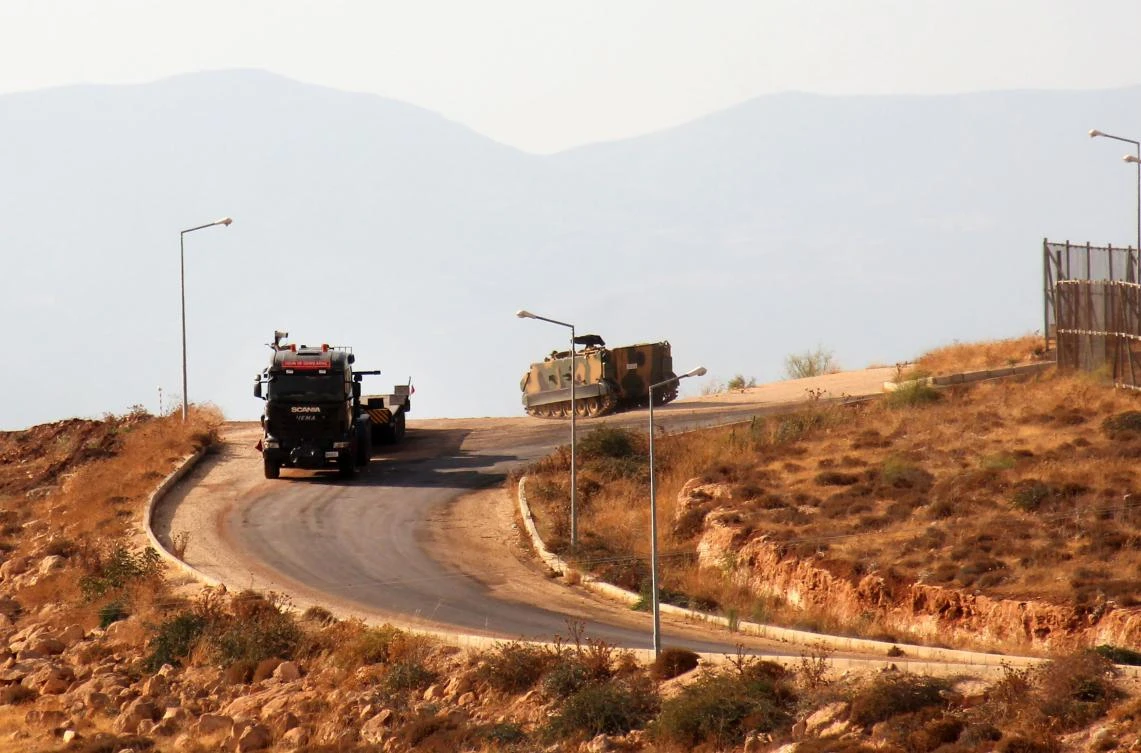 A picture taken on October 11, 2017, from the Syrian village of Atme in the northwestern province of Idlib shows Turkish military vehicles driving around a military base on the Turkish side of the border with Syria. (AFP)