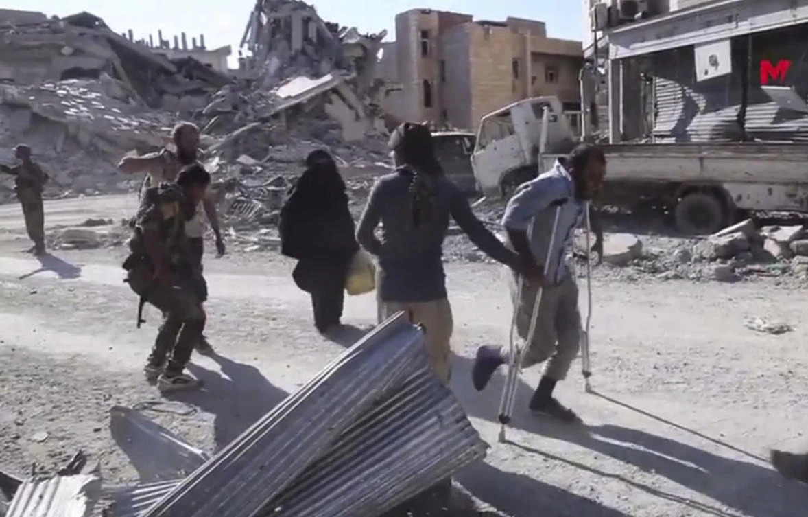 This frame grab from a video provided on Friday, Oct. 13, 2017 by Turkey-based Kurdish Mezopotamya agency media outlet shows Syrian civilians flee from the areas that still controlled by the Daesh militants, in Raqqa, Syria.(Mezopotamya Agency, via AP)