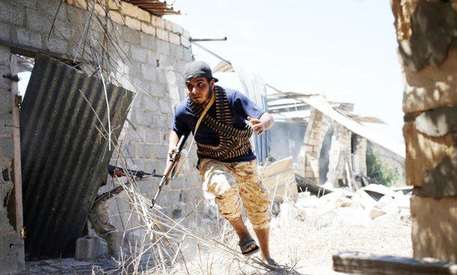A fighter of Libyan forces allied with the U.N.-backed government runs for cover during a battle with Daesh fighters in Sirte, Libya. (Reuters)