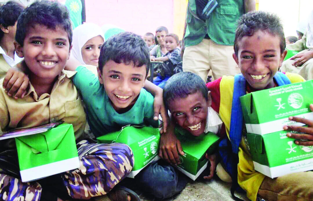 With smiles on their faces, Yemeni children carry the meals received from KSRelief officials in Taiz governorate, Yemen. (SPA)