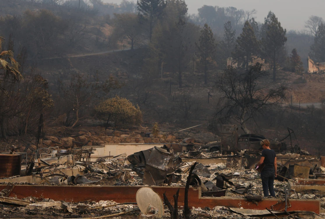 A woman surveys the remains of a home destroyed by wildfire in Napa, California. (Reuters)
