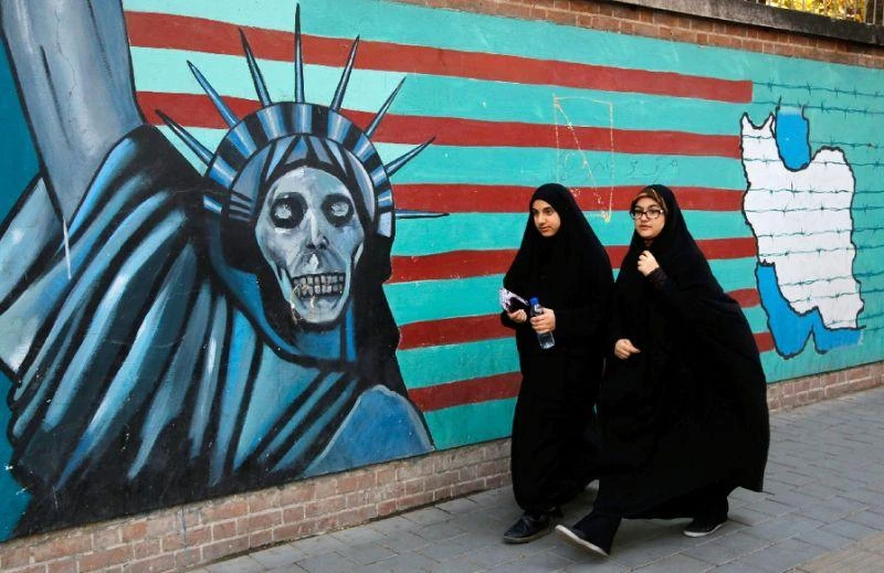 Iranian women walk past the former US embassy in Tehran on November 3, 2016 (AFP)