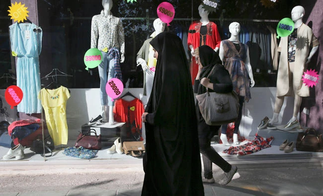 Iranian women walk past a clothes shop in downtown Tehran, Iran, on Saturday, Oct. 14, 2017. President Donald Trump's refusal to certify the Iran nuclear deal has sparked a new war of words between the Islamic Republic and America, fueling growing mistrust and a sense of nationalism among Iranians. (AP)