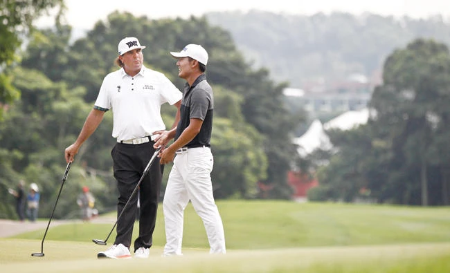 Pat Perez of the US, left, and Sung Hoon Kang of South Korea after their shots on the first hole during the third round of the CIMB Classic golf tournament at Tournament Players Club (TPC) in Kuala Lumpur Saturday. (AP)