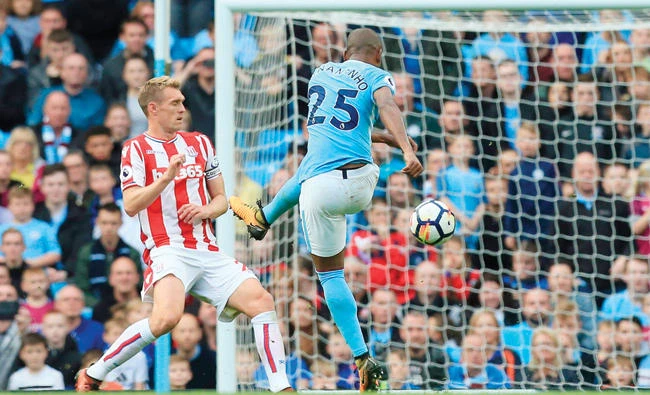 Manchester City’s Brazilian midfielder Fernandinho, right, scores their fifth goal during the English Premier League football match between Manchester City and Stoke City at the Etihad Stadium in Manchester, north west England, on Saturday. (AFP)