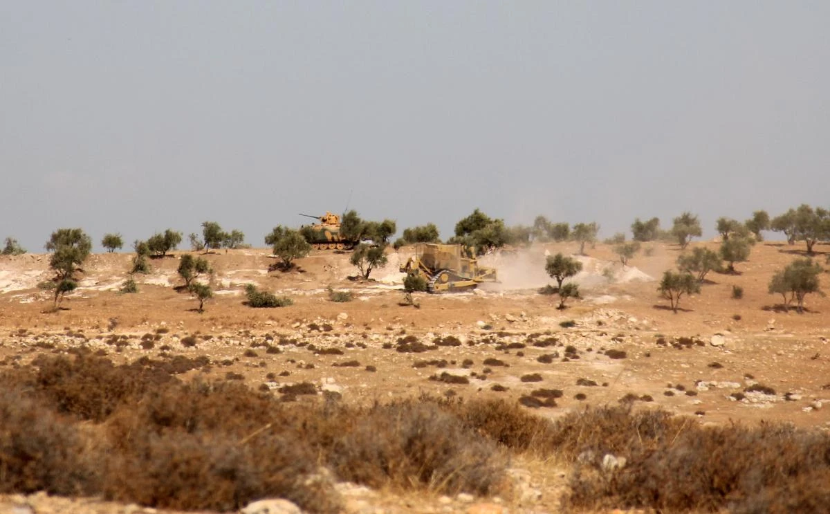Above, a Turkish army bulldozer and tank on a hill in the Syrian border town of Salwah. (AFP)