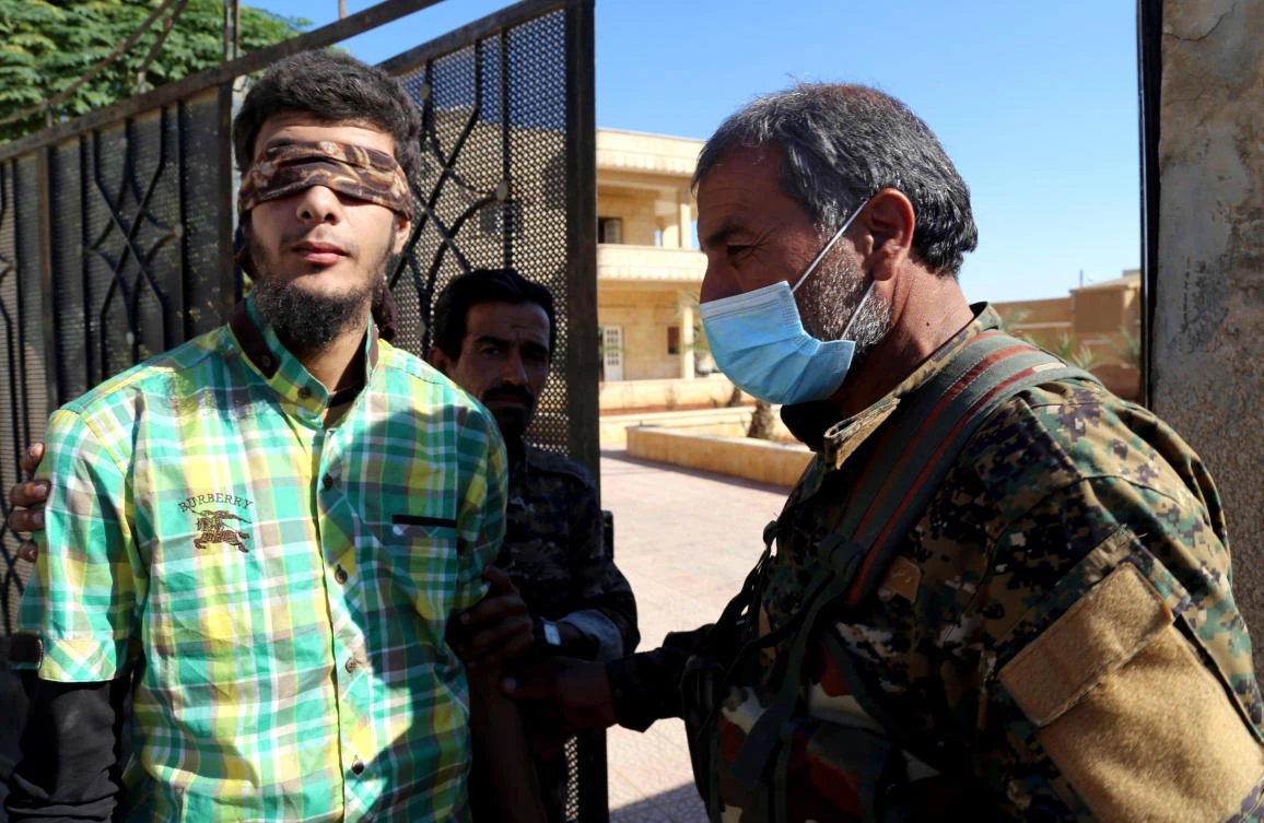 Above, members of Syrian Democratic Forces escort a blindfolded civilian detainee suspected to be a member of Daesh in Raqqa. (Reuters)