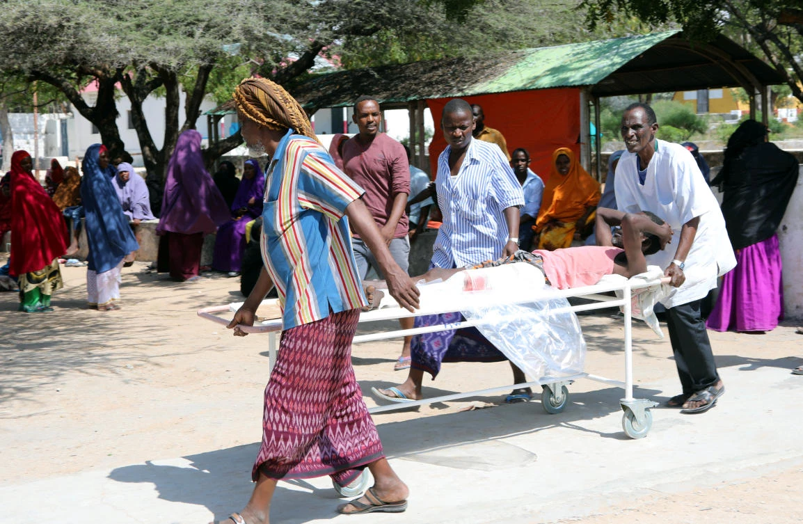 Relatives assist a man injured in an explosion in KM4 street in the Hodan district of Mogadishu on Sunday, October 15, 2017. (REUTERS/Feisal Omar)